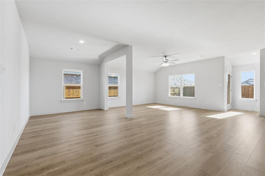 Unfurnished living room featuring light wood-style floors, recessed lighting, a ceiling fan, and vaulted ceiling