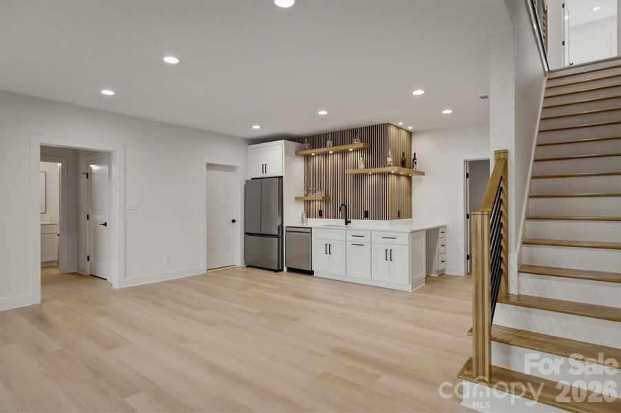 The staircase leads to this lower lounge area with plenty of room for furniture. There is a wet bar with a full size refrigerator, a sink, and a dishwasher. The staircase leads to this lower lounge area with plenty of room for furniture. There is a wet bar with a full size refrigerator, a sink, and a dishwasher.