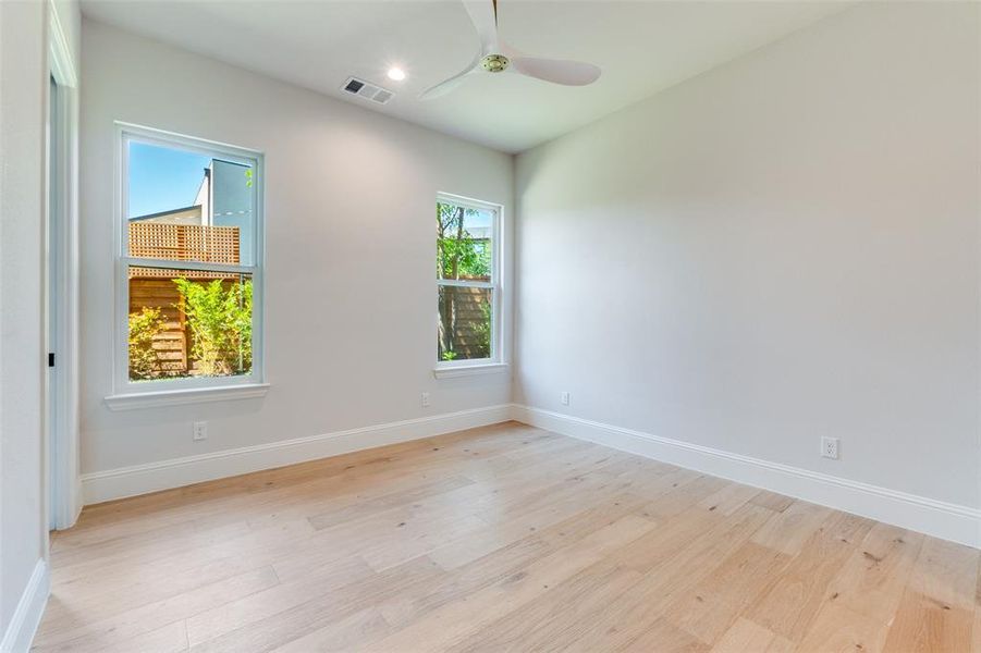 Empty room with light wood-style floors and a ceiling fan Empty room with light wood-style floors and a ceiling fan