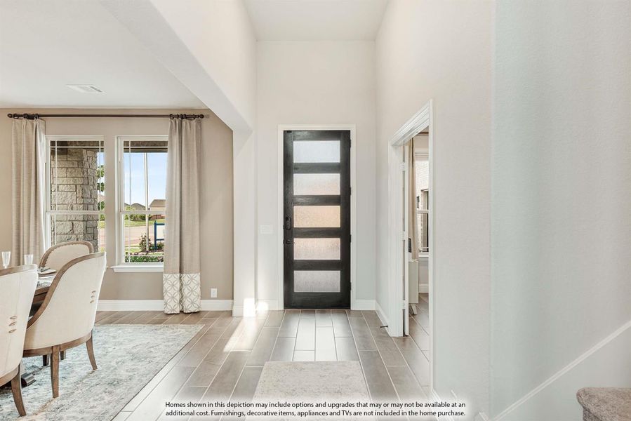 Entryway with dark glass-panel front door, tile floors, and adjacent dining area with large windows
