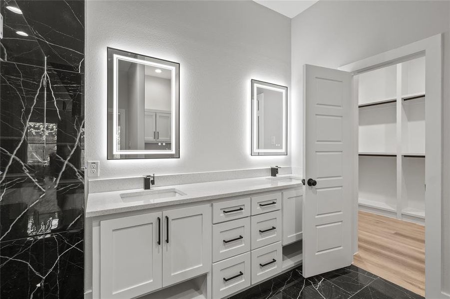 Bathroom featuring vanity, a tile shower, and wood-type flooring