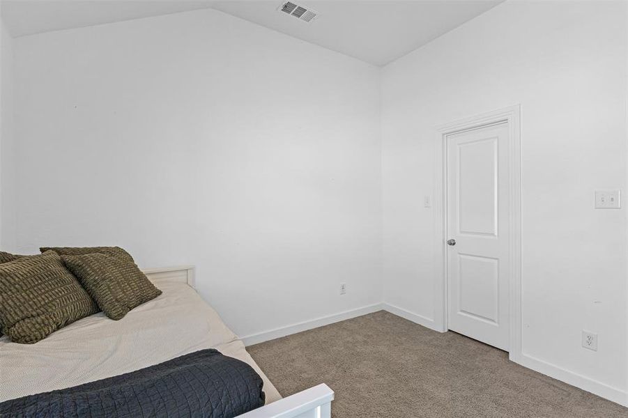 Bedroom featuring carpet floors and lofted ceiling