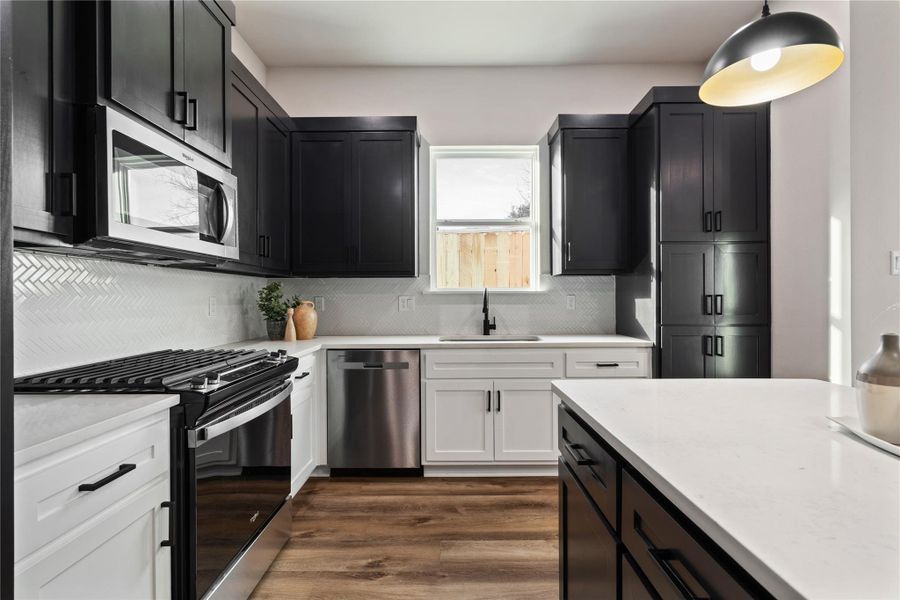 A beautifully finished kitchen blends modern style with everyday function, featuring crisp countertops, sleek cabinetry, and a clean, contemporary layout. The bright window over the sink adds a fresh, airy feel that makes the space feel warm and inviting.