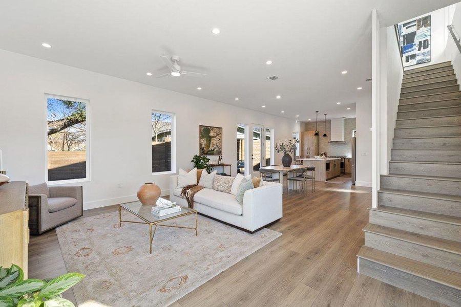 Living room featuring stairway, recessed lighting, light wood-type flooring, and a ceiling fan
