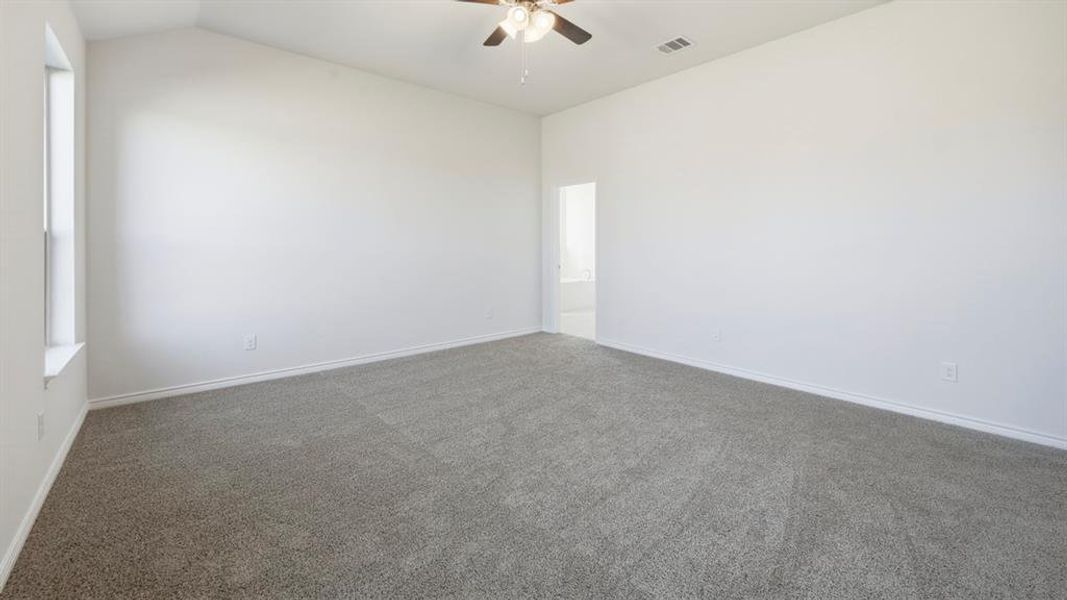 Empty room with carpet, a ceiling fan, and lofted ceiling