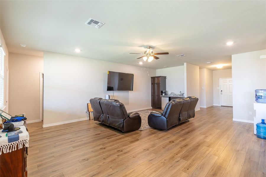 A living space with wood flooring and recessed lighting offers a comfortable atmosphere.