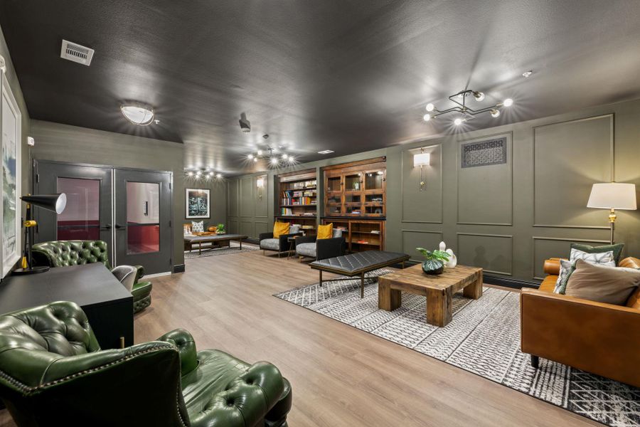 Cinema with a decorative wall, a chandelier, and wood finished floors