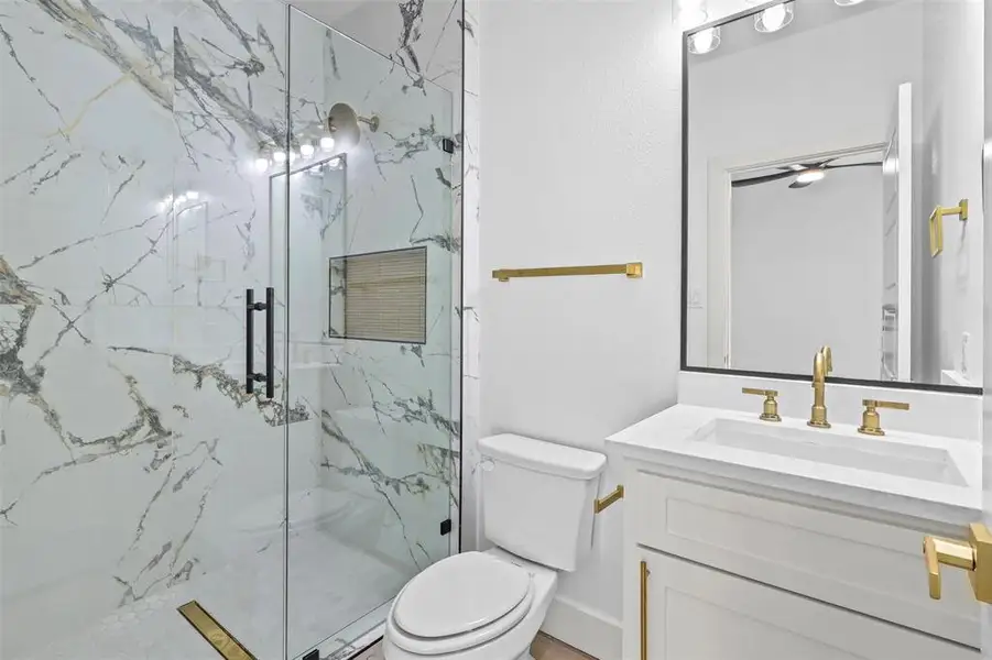 Bathroom featuring vanity and a marble finish shower
