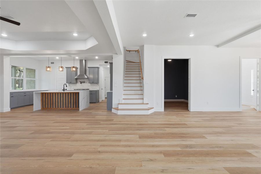 Open concept family room with movie room to the right of stairs and office on the far right of photo Open concept family room with movie room to the right of stairs and office on the far right of photo