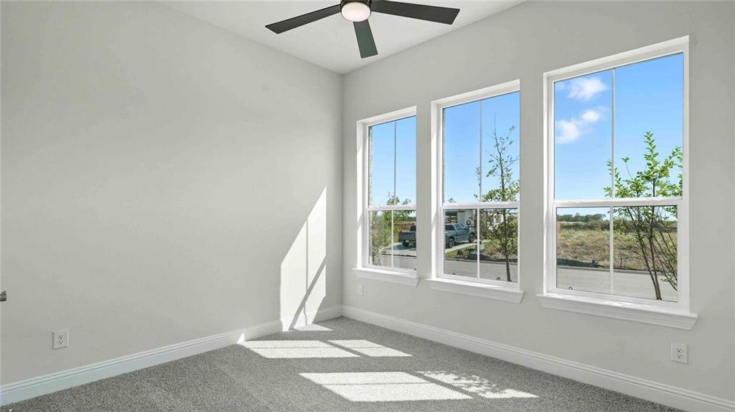 Empty room featuring a ceiling fan and light colored carpet