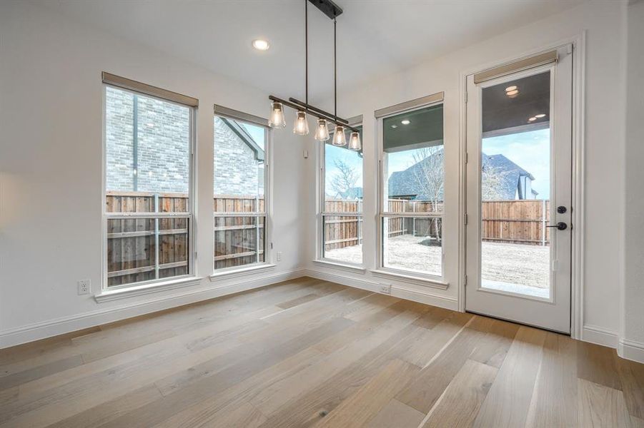 Unfurnished dining area with recessed lighting, wood finished floors, and baseboards