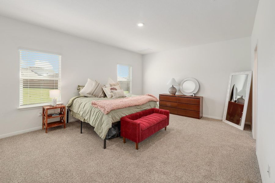 Spacious bedroom featuring neutral carpeting, two large windows, recessed ceiling lighting, and a neutral wall color throughout Spacious bedroom featuring neutral carpeting, two large windows, recessed ceiling lighting, and a neutral wall color throughout