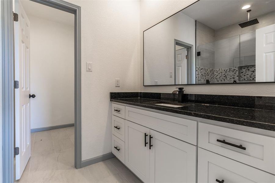 Bathroom featuring a shower and vanity