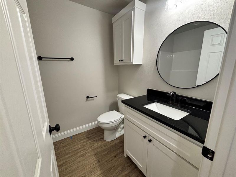 Bathroom with dark wood finished floors and vanity