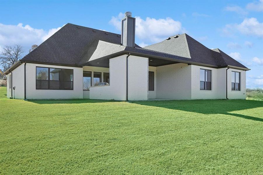 Rear view of house featuring a yard, brick siding, a patio, and a shingled roof Rear view of house featuring a yard, brick siding, a patio, and a shingled roof