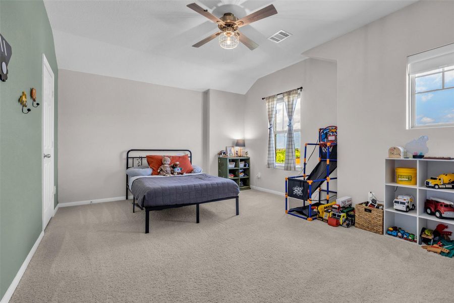 This second-floor bedroom overlooks the front of the home and features carpeted flooring with a couple of windows that bring in plenty of natural light.
