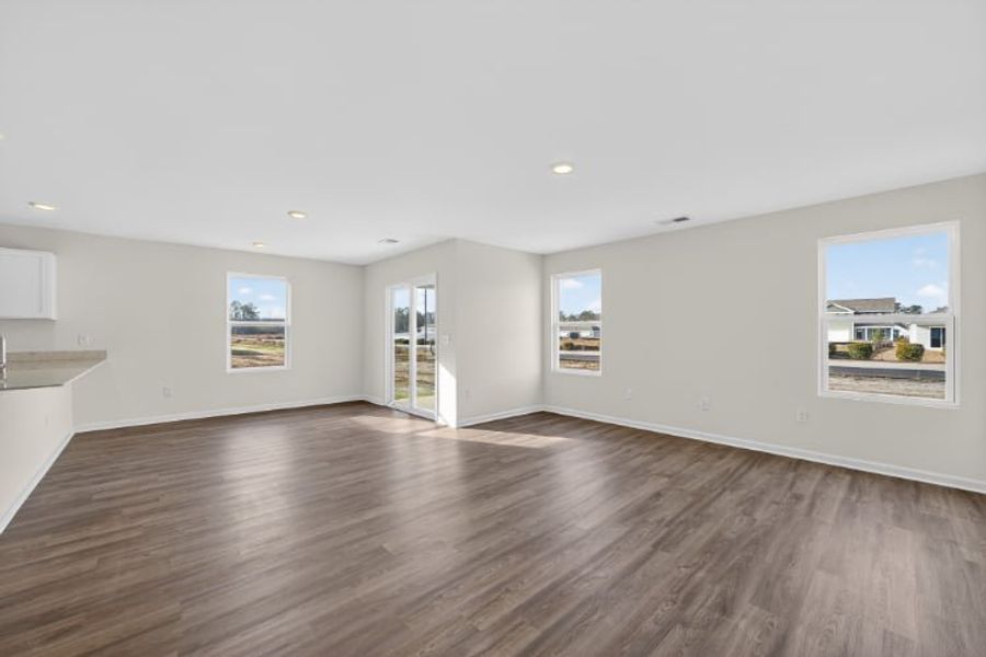 A large empty room with a wood floor and a large window.