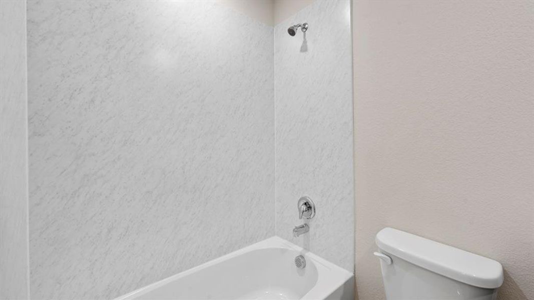 Bathroom with shower / bath combination and a textured wall