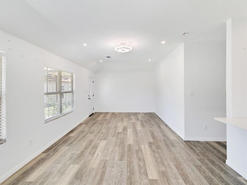 Open concept living area featuring wood-finish flooring, recessed lighting, and a modern ceiling light fixture
