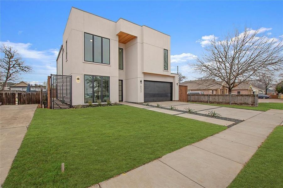 Contemporary house featuring a front yard and a garage