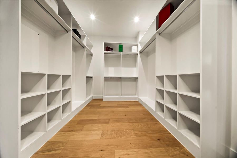 Walk in closet with light wood-style floors Walk in closet with light wood-style floors