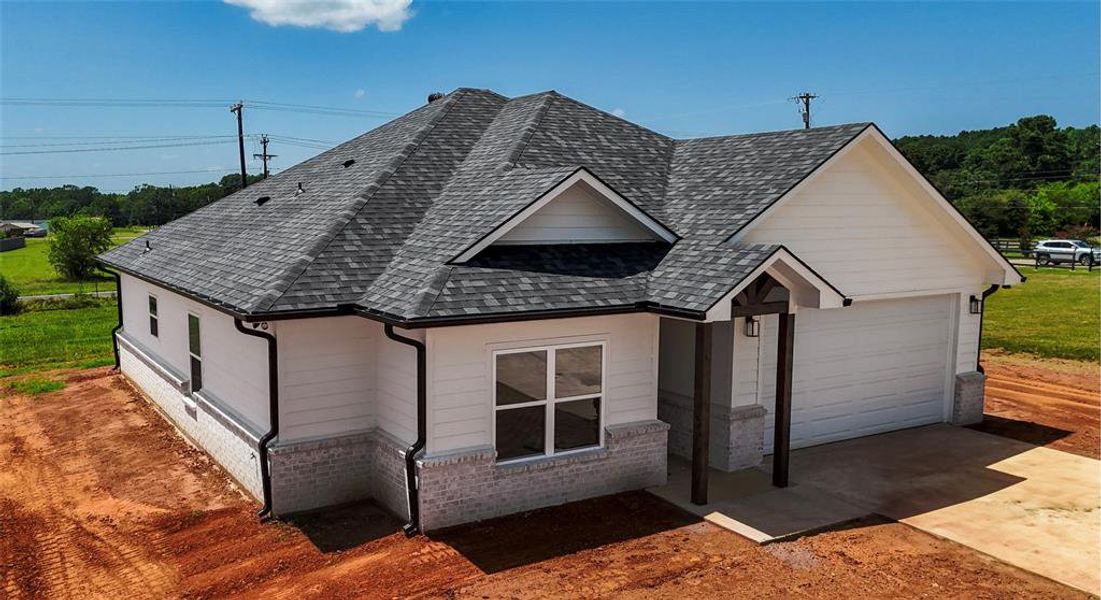 View of front of home with concrete driveway, an attached garage, a shingled roof, and brick siding View of front of home with concrete driveway, an attached garage, a shingled roof, and brick siding