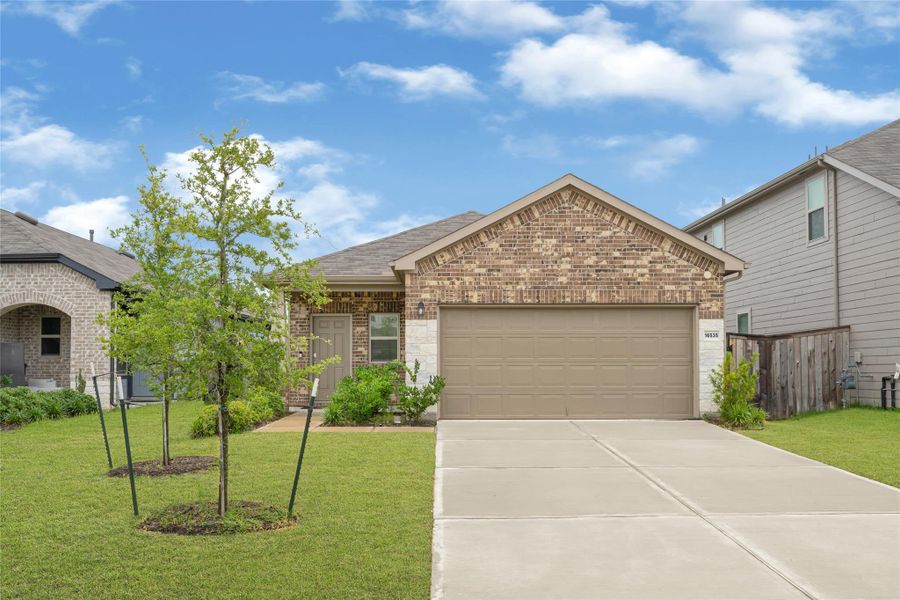 Alternative front exterior angle highlighting the neat concrete driveway and cozy covered entryway.