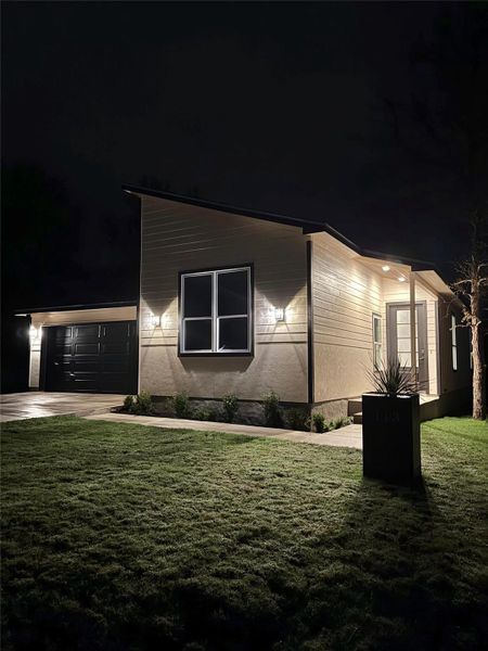 View of front facade featuring a lawn, driveway, and an attached garage