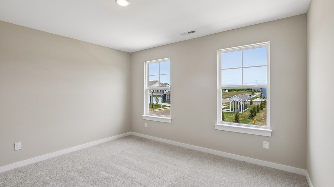 Bedroom with walk-in closet and windows