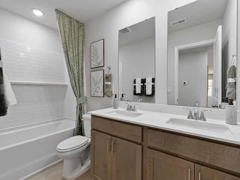 The upstairs secondary bathroom features dual sinks and a tub/shower combo.