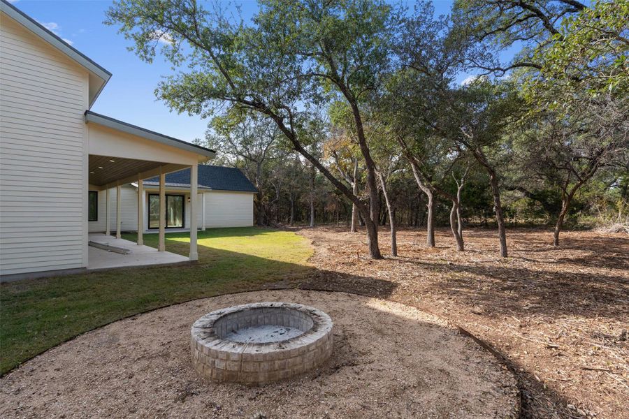 View of green lawn featuring a patio area View of green lawn featuring a patio area