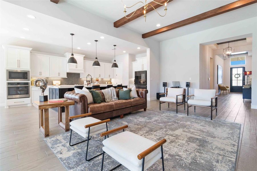 Living room featuring beamed ceiling, a chandelier, light wood finished floors, and recessed lighting Living room featuring beamed ceiling, a chandelier, light wood finished floors, and recessed lighting