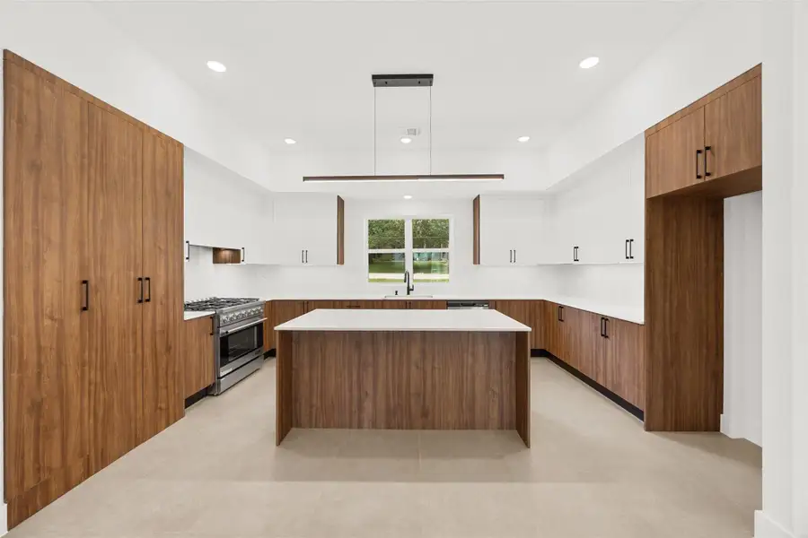 Beautiful blend of warm wood cabinetry, crisp white finishes, and a spacious island.