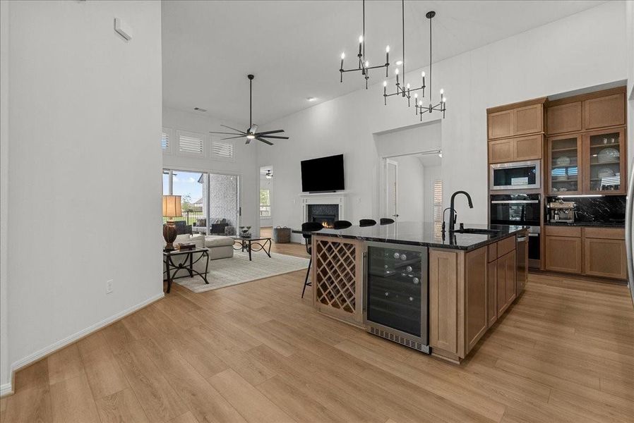 Chef’s kitchen overlooks the spacious living area and boasts double ovens, pot filler, granite countertops, designer backsplash, upgraded cabinetry, stainless steel appliances, stylish finishes, and oversized island seating.