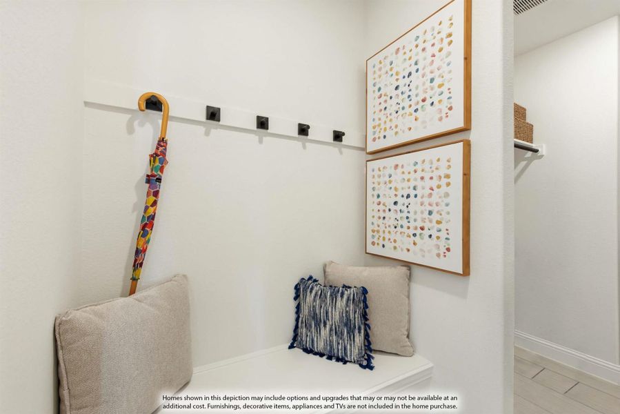 Mudroom nook with built-in bench, wall hooks, and two framed art pieces above seating area