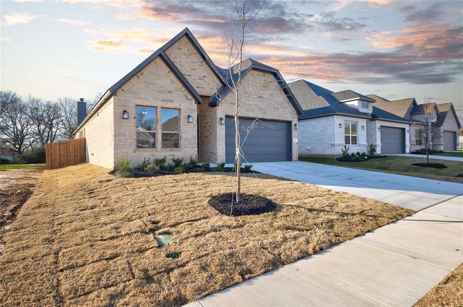 View of front of property featuring a yard and a garage