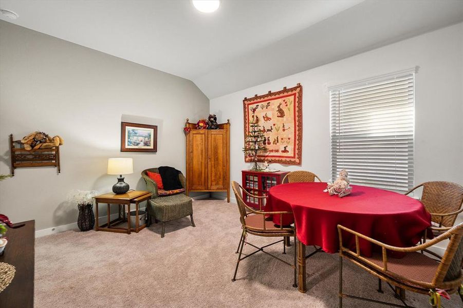 Dining area featuring vaulted ceiling and light carpet Dining area featuring vaulted ceiling and light carpet