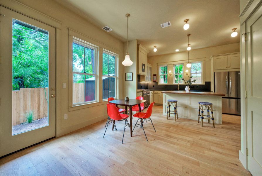 A luminous open-concept space features a well-appointed kitchen and dining area with hardwood floors and abundant natural light.