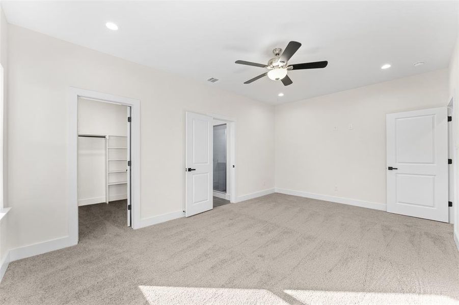 Unfurnished bedroom with a walk in closet, light colored carpet, recessed lighting, and ceiling fan Unfurnished bedroom with a walk in closet, light colored carpet, recessed lighting, and ceiling fan