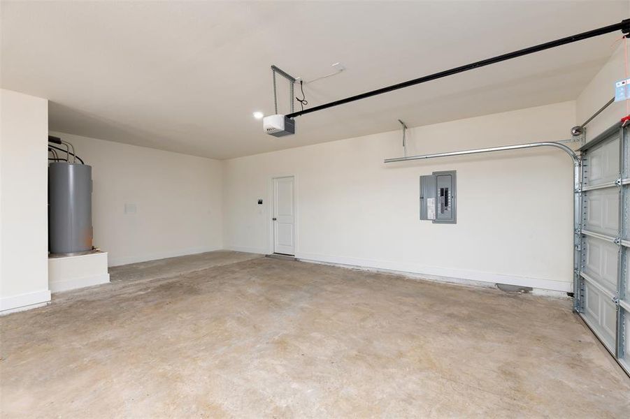 Garage featuring water heater, baseboards, a garage door opener, and electric panel