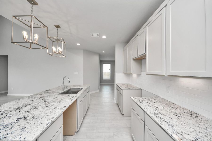 The extended counter area adds both practicality and style, making meal preparation a breeze. Every detail is thoughtfully designed to enhance the kitchen's functionality and aesthetic appeal. Sample photo of completed home with similar floor plan. Actual colors and selections may vary.