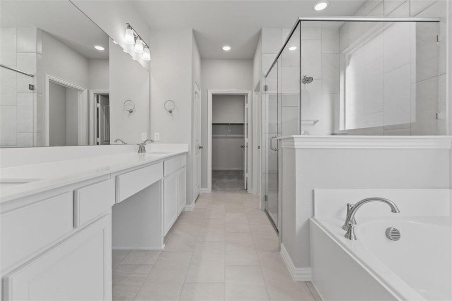 Full bath featuring double vanity, a stall shower, a garden tub, a walk in closet, and light tile patterned floors