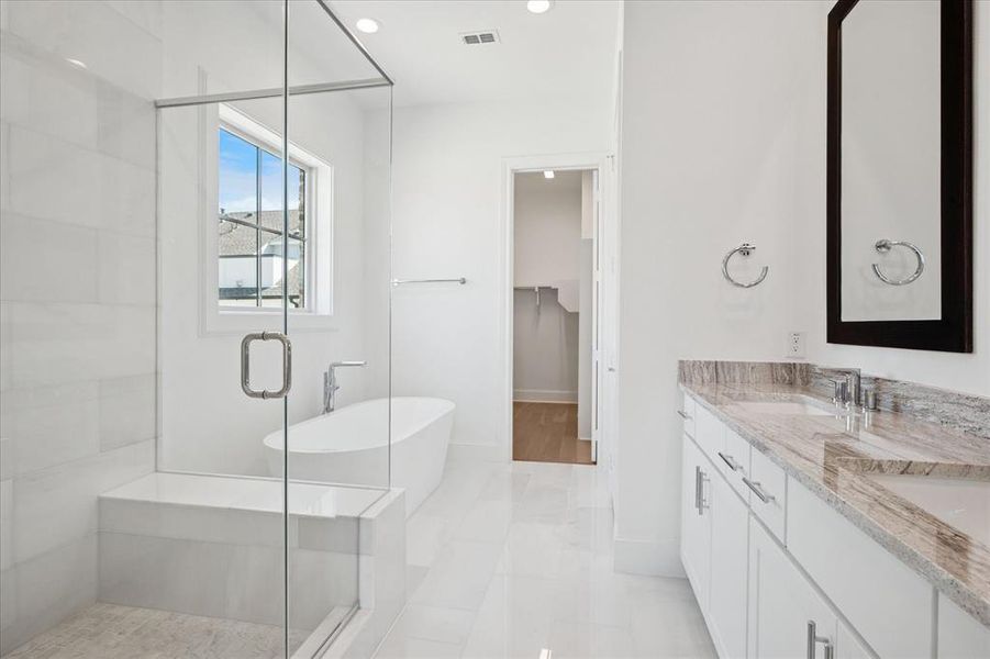 Full bath featuring a stall shower, a spacious closet, double vanity, a soaking tub, and recessed lighting Full bath featuring a stall shower, a spacious closet, double vanity, a soaking tub, and recessed lighting