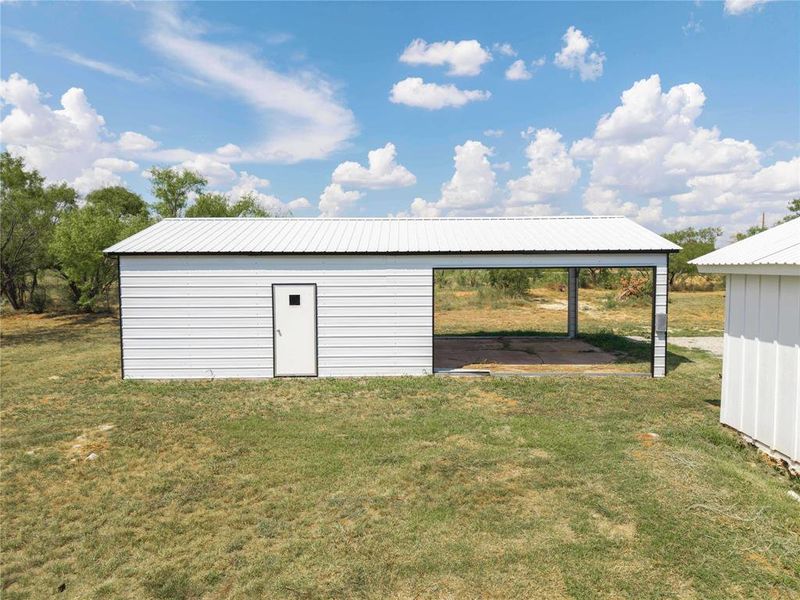 View of pole building with a yard and a detached carport
