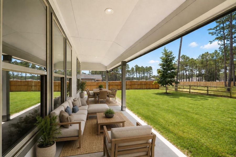 Spacious covered patio overlooking a lush, fenced backyard perfect for relaxation and outdoor activities. *Virtually staged