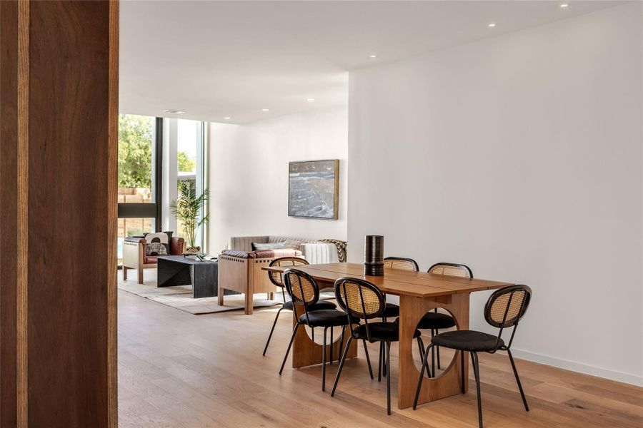 Dining area featuring a wall of windows, light wood finished floors, and recessed lighting