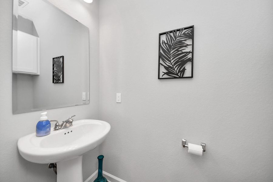 This bright, modern bathroom features a sleek pedestal sink, large mirror, and stylish wall art. Perfect for a contemporary home. This bright, modern bathroom features a sleek pedestal sink, large mirror, and stylish wall art. Perfect for a contemporary home.