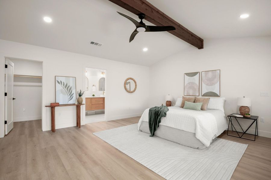 Bedroom featuring recessed lighting, lofted ceiling with beams, a walk in closet, light wood-style floors, and a ceiling fan