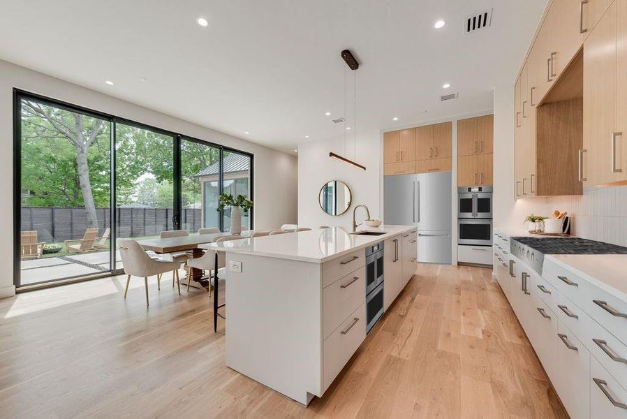 The modern kitchen is centered around an oversized island with uninterrupted views of the backyard.