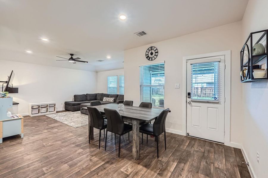 Dining room with visible vents, a ceiling fan, plenty of natural light, and dark wood-style floors